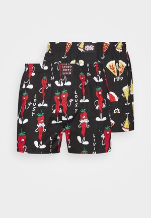 Schwarze Shorts mit verspielten Grafiken von Chili-Pfeffern und Pizzen. Mit elastischem Bund und weichem Material. Wendbares Design mit lebhaften Mustern.
