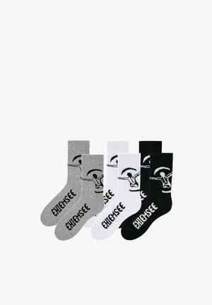 Three pairs of socks in gray, white, and black, each with a hang gliding graphic and the word "CHIEMSEE" printed on the foot and leg.