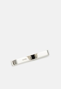 Pince à cravate en argent avec une texture métallique polie, présentant une forme lisse et allongée, et un logo "BOSS" en relief d'un côté.