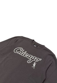 Sudadera gris con cuello redondo. Presenta un gran texto blanco que dice "Chicago" y un logo de los White Sox. Está hecha de una tela suave con un ajuste relajado.
