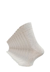Chaussettes beige à la cheville disposées en séquence. Fabriquées en un tissu lisse et doux avec une bordure côtelée, présentant un mélange de fils clairs et foncés.