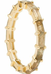 Bague en or doré ornée de pierres rectangulaires gris-brun, disposées dans un design géométrique avec des accents en métal et des surfaces lisses et polies.