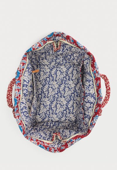 Μεγάλη ανοιχτή τσάντα ώμου με μπαλώματα σε μπλε, λευκό, κόκκινο και τιρκουάζ, με εσωτερική τσέπη με φερμουάρ και υφασμάτινες λαβές.