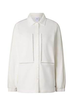 White long-sleeve button-up shirt with perforated trim along sleeves, pockets, and front, featuring a classic collar and elastic cuffs.