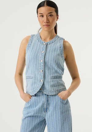 Blauwe denim mouwloze vest met verticale witte strepen, ronde halslijn, knopen aan de voorkant en twee zijzakken. Afgeronde zoom en gestructureerde stof.