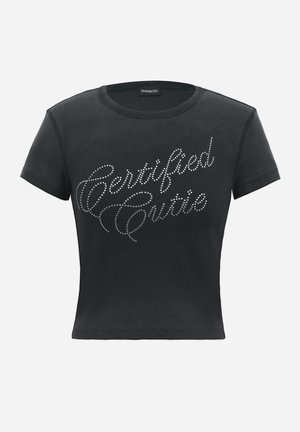 Must lühikeste varrukatega lühike t-särk ümmarguse kaelusega ja ees kirjadega kivikestega, mis ütlevad "Certified Cutie".