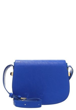 Blauwe leren crossbodytas met verstelbare riem, ronde onderkant en subtiel gegraveerd logo in het midden vooraan.