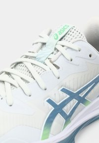 Scarpa da corsa Asics bianca e blu con lacci bianchi, linguetta in mesh e logo sul lato e sulla linguetta su sfondo semplice.