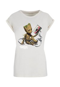 Cotton T-shirt in light beige featuring a graphic of a character holding a cassette tape with black cord accents. Short rolled sleeves.