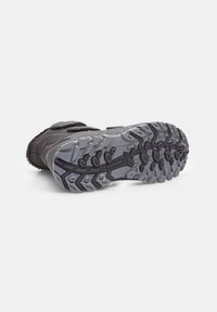 Scarpa atletica nera con suola in gomma grigia robusta, caratterizzata da un battistrada a motivo per una migliore aderenza e una fascia in velcro per la chiusura.