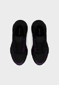 Ζευγάρι μαύρων και σκούρων μοβ αθλητικών παπουτσιών με κορδόνια, που φαίνονται από πάνω σε ανοιχτό φόντο, με την ένδειξη "Pier One" εσωτερικά.