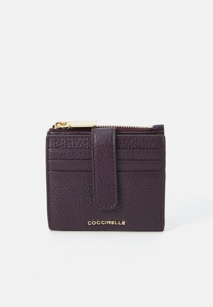 Purple leather wallet with a textured finish, featuring a zippered compartment and slots for cards. Gold hardware logo detail included.