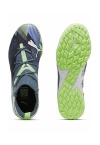 Zapatillas deportivas con parte superior de malla azul marino, acentos verdes y suela texturizada. Incluyen un cuello acolchado, diseño con cordones y un logo distintivo.