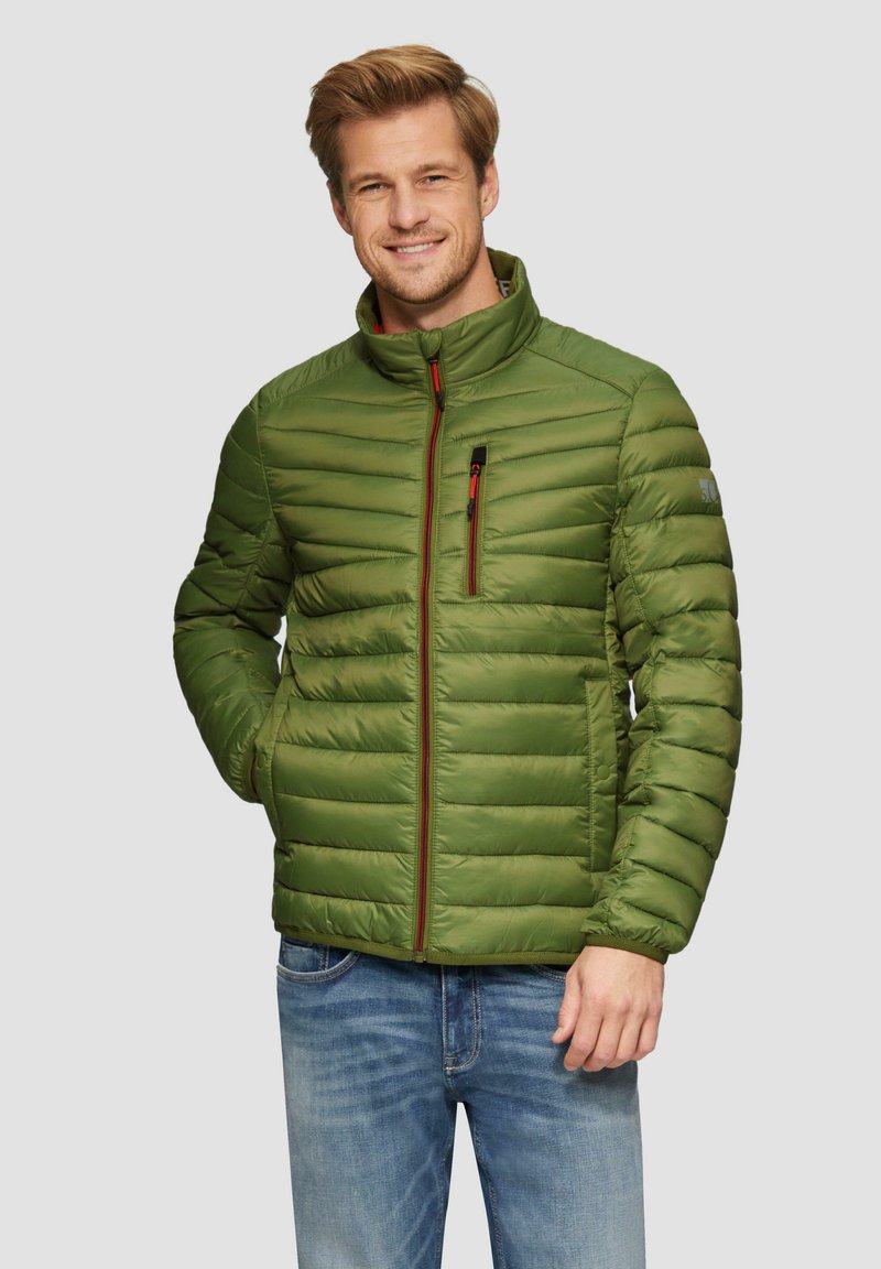Grüne gesteppte Pufferjacke mit hohem Kragen, seitlichen Taschen und einer mit Reißverschluss versehenen Brusttasche, mit roten Akzenten und strukturiertem Stoff.