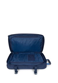 Maleta de concha blanda azul marino con un interior espacioso y forrado, que cuenta con correas y un bolsillo de malla para organización y embalaje seguro.