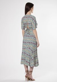 Abito con stampa geometrica multicolore, maniche corte, dettaglio di legatura sul retro e gonna fluida. Presenta un tessuto leggero e una vestibilità comoda.
