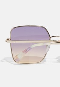 Square sunglasses with a gold metal frame and gradient lenses transitioning from purple to light brown. Clear acetate temple tips.