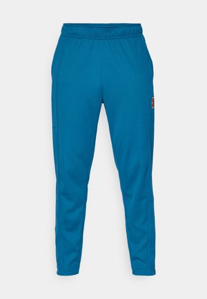 Blaue tapered Jogginghose mit elastischem Bund und seitlichen Taschen, mit einem kleinen rechteckigen Logo auf dem Oberschenkel.