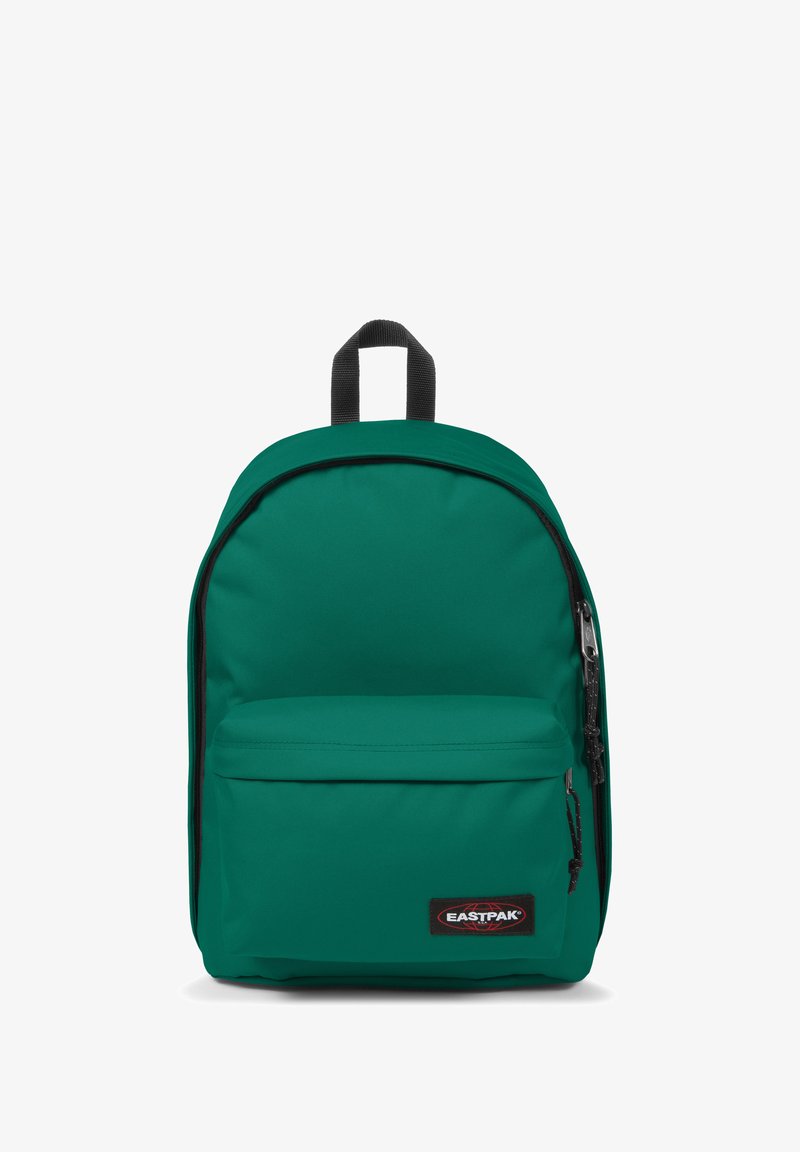 Mochila de tela verde con parte superior redondeada, bolsillo frontal con cremallera y detalles en negro. Cuenta con un asa superior y correas de hombro acolchadas.