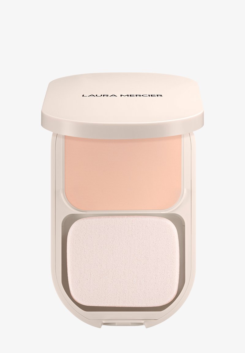 Poudre compacte beige avec une éponge de maquillage rectangulaire à l'intérieur d'un boîtier beige clair étiqueté "Laura Mercier" sur le couvercle.