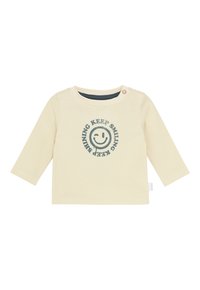 Hellebärige Langarm-Babyshirt mit Knopf an der Schulter und blauer Smiley-Gesicht-Grafik mit dem Text "HALTE DAS LÄCHELN, HALTE DAS STRAHLEN".
