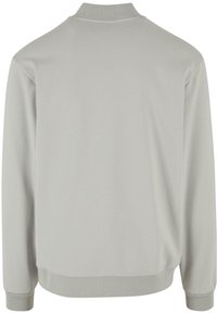 Felpa grigia chiara con colletto alto, polsini e orlo a coste; presenta una texture liscia e un design semplice.