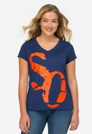 Camiseta de manga corta en azul marino con un gran estampado gráfico en color naranja de la letra "S" con un acabado texturizado y un escote en V.