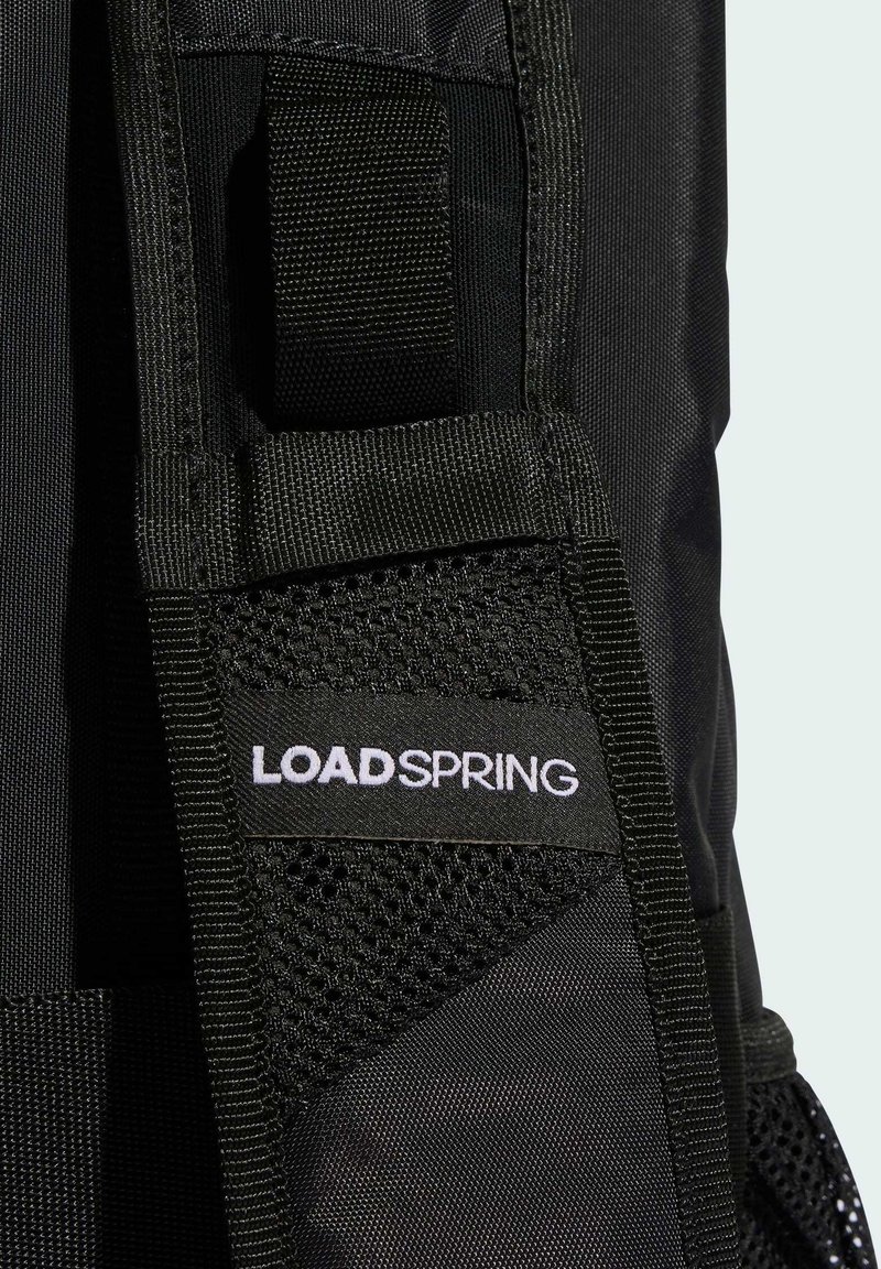 Svart ryggsäck med texturerat tyg, meshdetaljer och en framträdande vit "LOADSPRING"-logotyp. Justerbar rem ingår.