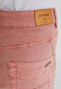 Rosa denimshorts med en märkesläderpatch, kompakt design på bakfickan och subtila sömnadsdetaljer.