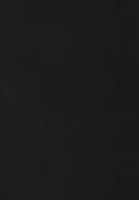 Surface texturée noire avec une finition mate, présentant des motifs abstraits et des formes variées créés par la lumière et l'ombre.