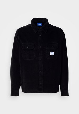 Black corduroy shirt with button-up front, collar, two chest pockets, and HUGO logo label. Ribbed texture and long sleeves.
