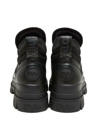 Zapatillas negras de caña alta que combinan tela texturizada y cuero liso, con una marca distintiva en los talones y suelas gruesas.