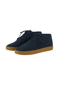 Zapatos de ante azul marino hasta el tobillo con punta redondeada, suela de goma plana en color beige y diseño de cordones. Textura suave con detalles de costura mínimos.