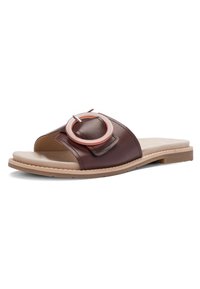 Brun læder slidssandal med stor rund spænde og beige polstret sål på en flad gummiydersål.