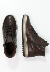 Braune Leder-Hochtop-Sneaker mit Schnürung an der Vorderseite, seitlichem Reißverschluss und strukturiertem Gummisohle, die ein glattes Finish und dezente Nähte aufweisen.