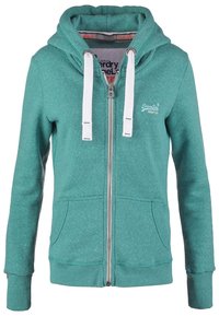 Sudadera con cremallera en color verde azulado, con capucha ajustable, detalles en blanco y dos bolsillos frontales. Fabricada en un tejido suave con textura moteada.