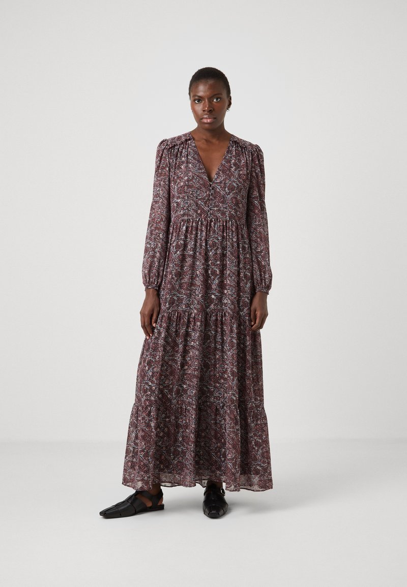 Rochie maxi într-o nuanță roșu închis cu print floral. Mâneci lungi și bufante, decolteu în V și design în straturi. Asortată cu sandale plate negre.
