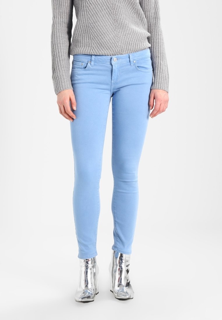 Jeans skinny azul claro en tejido elástico con una textura suave, que cuentan con un diseño clásico de cinco bolsillos y detalles de costura sutiles.