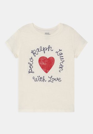 Biała koszulka z krótkim rękawem z czerwonym sercem i granatowym tekstem pisanym kursywą "Polo Ralph Lauren With Love" wokół niego.