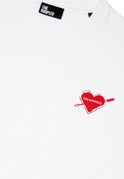 Hvid bomulds t-shirt med et rødt hjertegrafik med en pil og teksten "THE KOOPLES". Rund hals og korte ærmer.