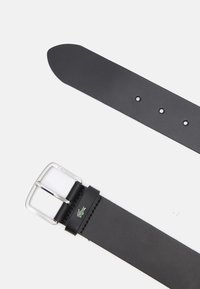 Black leather belt with a silver metal buckle, featuring a small green Lacoste logo and multiple holes for adjustment. Smooth texture, classic design.
