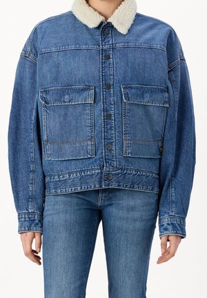 Veste en denim avec col en sherpa, comportant deux grandes poches avant, un lavage bleu et un système de fermeture à boutons. Coupe décontractée avec des manches longues.