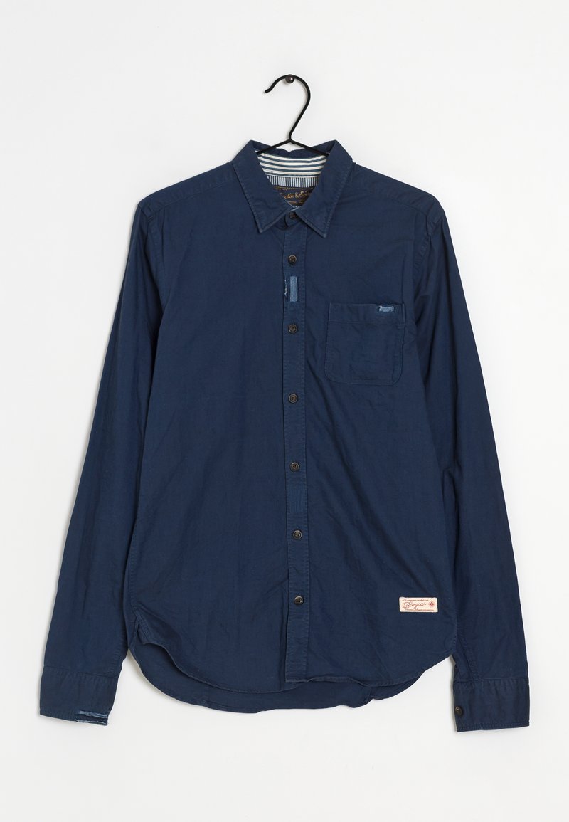 Tummansininen pitkähihainen puuvillapaita, jossa on napitettava etuosa, kaulus, yksi rintatasku ja kaareva helma. Sisältää tarralapun.