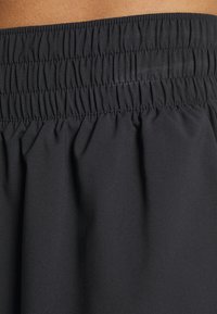 Schwarzer elastischer Bund mit geraffter Textur, hergestellt aus glattem Stoff, der weich fällt. Ohne zusätzliche Muster oder Beschläge.