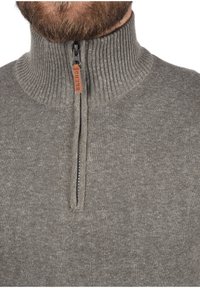 Maglione grigio con zip e colletto alto a costine, dotato di un'etichetta in pelle etichettata "BLEND" e un motivo a maglia testurizzato.