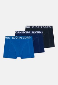 Tre par med boxershorts: en lys blå, en marineblå og en svart. Hver av dem har en hvit "BJÖRN BORG" logo på midjebåndet. Myk bomullsstoff.