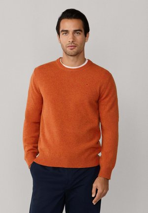 Orange wool sweater with a round neckline and ribbed cuffs. Smooth texture, fitted design, featuring a small, subtle logo detail.