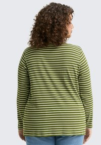 Maglietta verde a maniche lunghe con righe orizzontali bianche, dotata di scollatura a girocollo e vestibilità rilassata. Tessuto morbido con dettagli delle cuciture visibili.