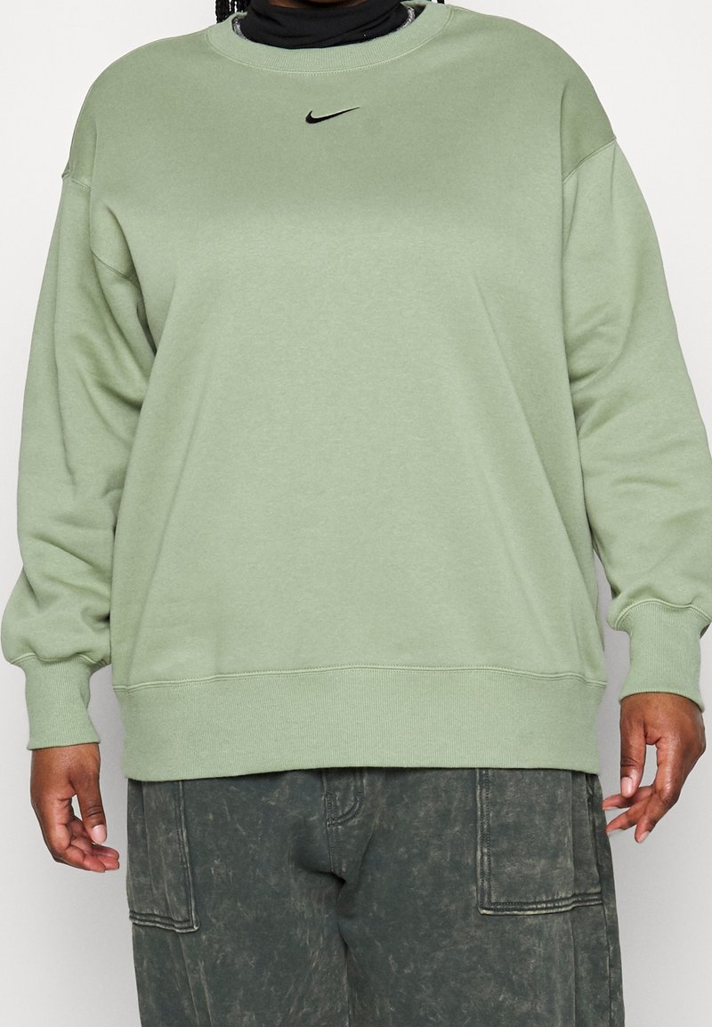 Grön sweatshirt i mjukt tyg med rund halsringning och en liten svart Nike-logotyp på bröstet. Lös passform med ribbade muddar.