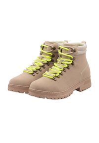Botas de senderismo beige con material texturizado, cordones de neón amarillos en contraste, ojales de metal y suela de goma con un patrón de agarre.